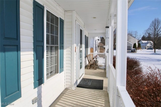 snow covered patio featuring a porch