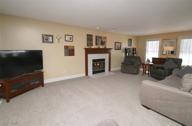 living room featuring a tiled fireplace and carpet floors