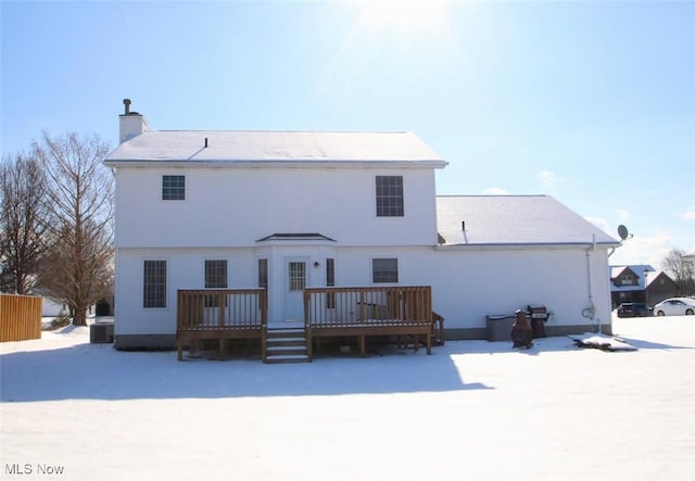 snow covered house with central AC and a deck