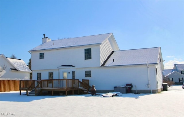 snow covered rear of property featuring a wooden deck