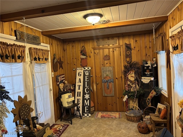 miscellaneous room featuring beamed ceiling and wooden walls