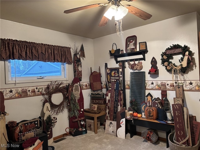 interior space with ceiling fan and carpet