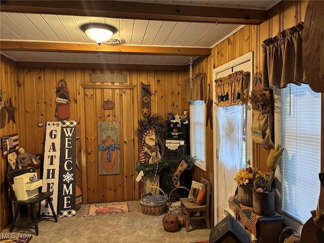 interior space featuring beam ceiling and wood walls