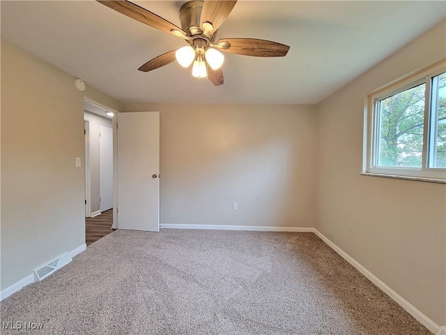 carpeted spare room with ceiling fan