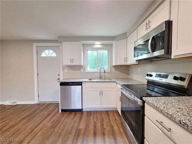 kitchen with white cabinetry, appliances with stainless steel finishes, sink, and hardwood / wood-style floors