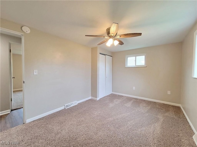 unfurnished bedroom with carpet floors, a closet, and ceiling fan