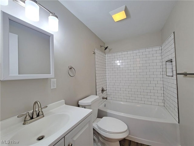 full bathroom with vanity, tiled shower / bath, and toilet