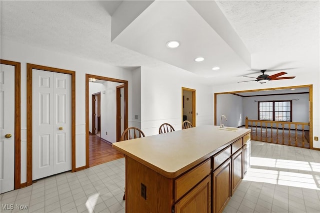 34210 Beacon Dr, Willoughby, OH 44094 - kitchen featuring ceiling fan, sink, an island with sink, and a textured ceiling
