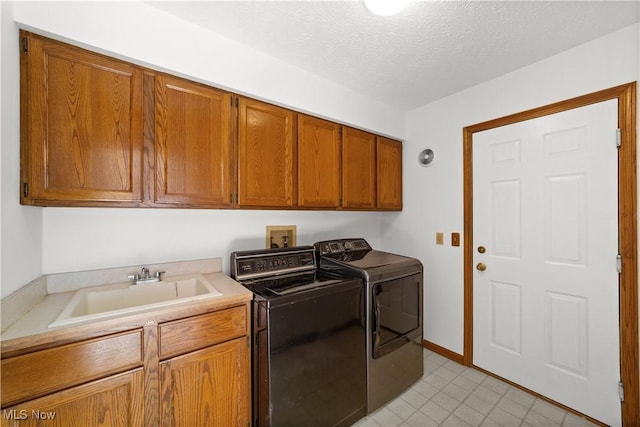 34210 Beacon Dr, Willoughby, OH 44094 - laundry room with cabinets, washer and clothes dryer, sink, and a textured ceiling