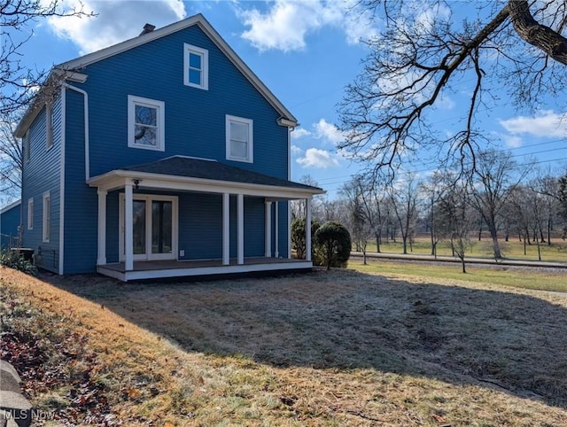 back of property with a porch and a lawn