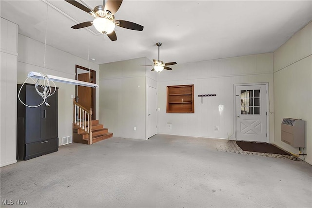 unfurnished living room featuring heating unit and ceiling fan