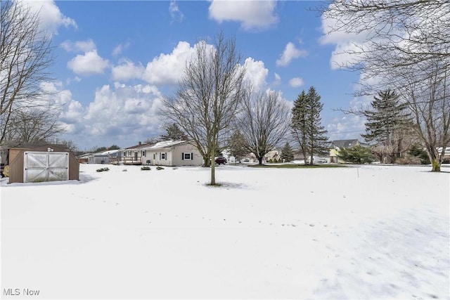 yard covered in snow featuring a storage unit