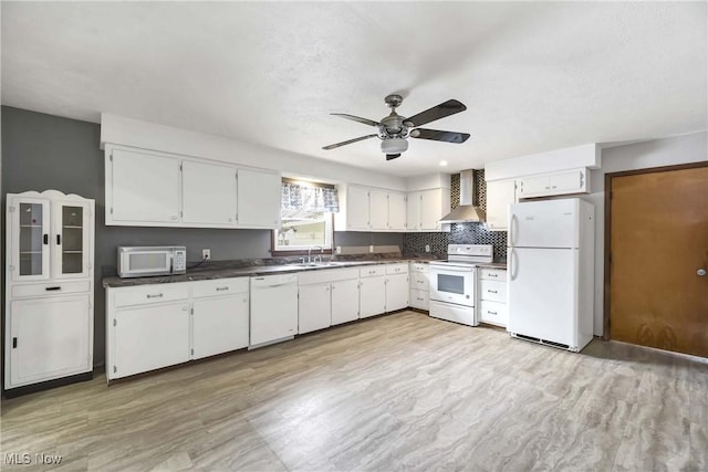 kitchen with white cabinetry, white appliances, wall chimney exhaust hood, and sink