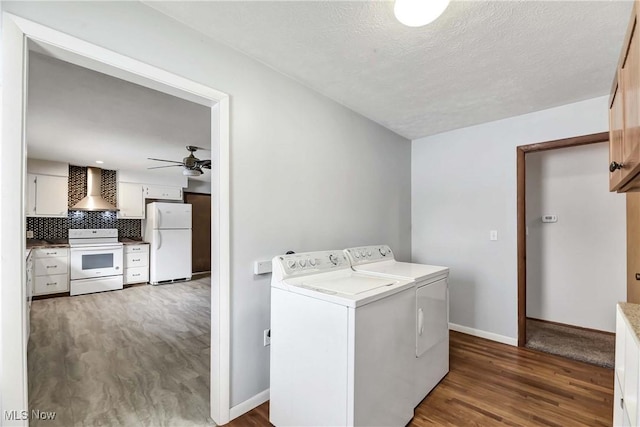 washroom with washing machine and dryer, a textured ceiling, ceiling fan, and dark hardwood / wood-style flooring