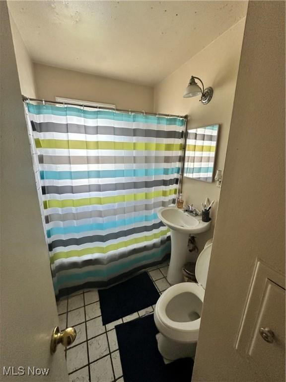 bathroom featuring tile patterned flooring, sink, and toilet