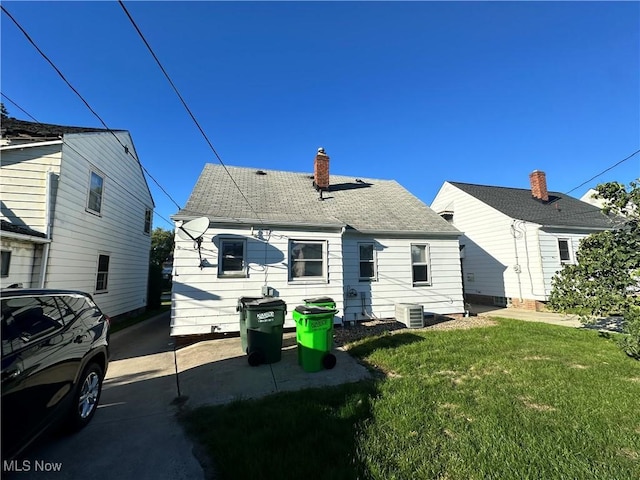 back of property featuring a yard and central AC unit