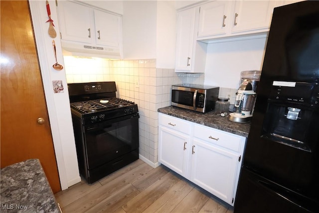 kitchen with white cabinetry, light hardwood / wood-style flooring, black appliances, and dark stone counters