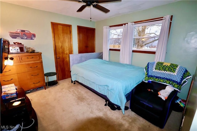 bedroom featuring light carpet and ceiling fan