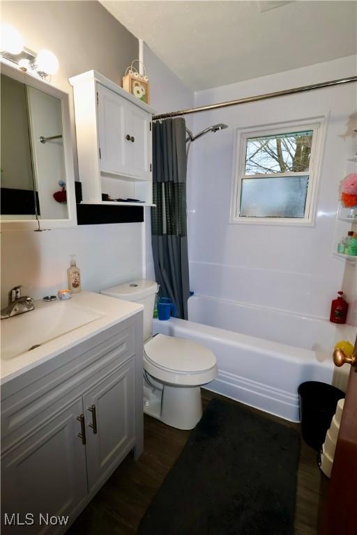 full bathroom featuring shower / bath combination with curtain, wood-type flooring, toilet, and vanity