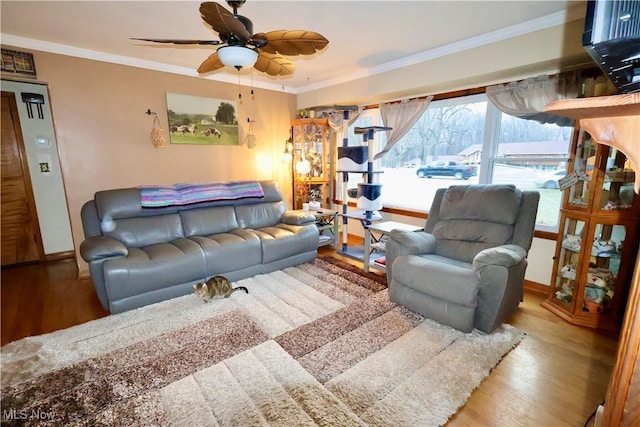 living room with hardwood / wood-style flooring, ornamental molding, and ceiling fan