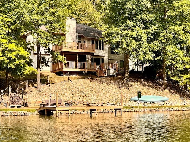 back of property with a deck with water view