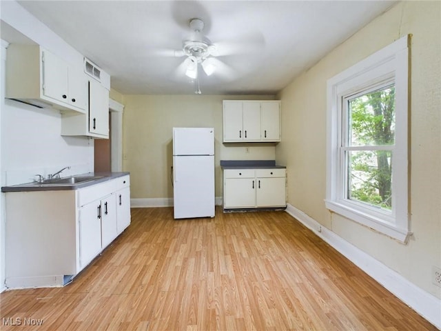 kitchen featuring sink, ceiling fan, white refrigerator, light hardwood / wood-style floors, and white cabinets