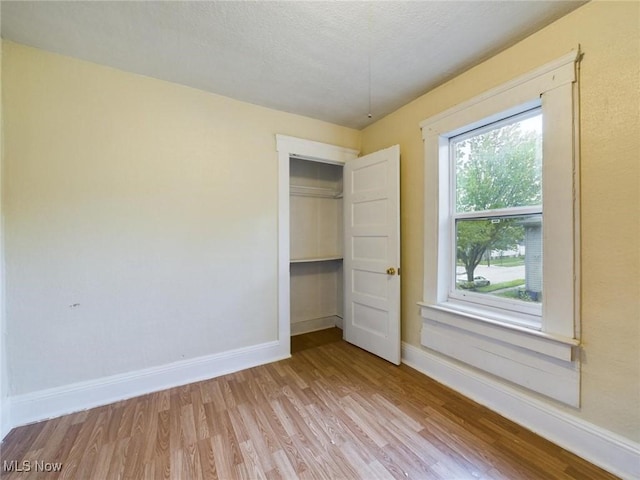 unfurnished bedroom with a closet and light hardwood / wood-style flooring