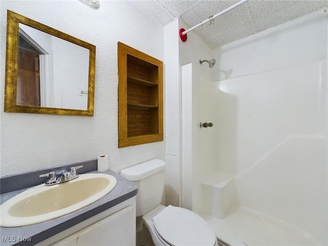 bathroom featuring vanity, toilet, and walk in shower