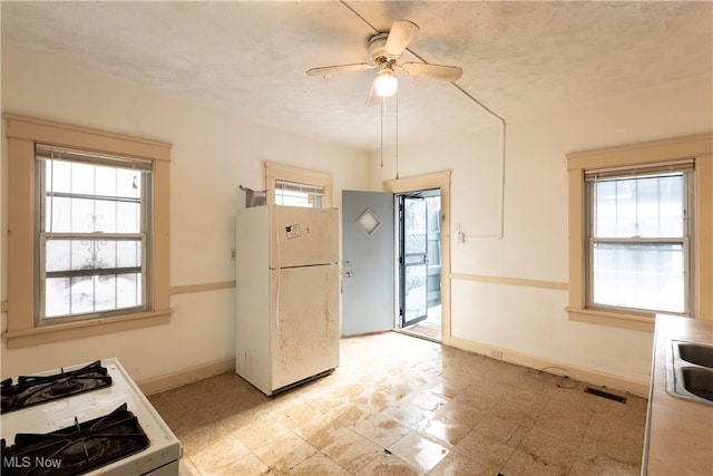 kitchen with sink, white appliances, and ceiling fan