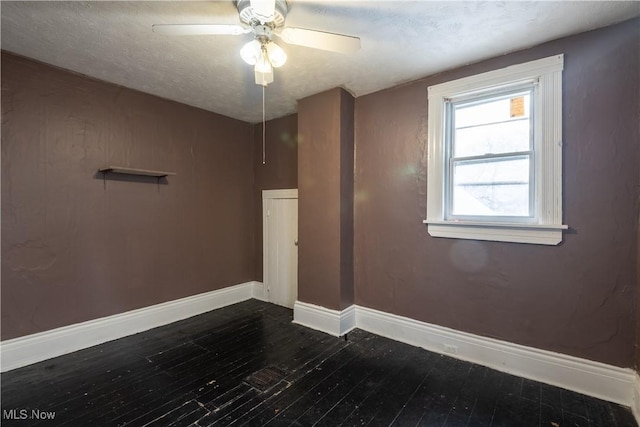 spare room featuring ceiling fan, dark hardwood / wood-style flooring, and a textured ceiling