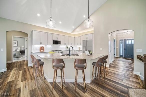 kitchen featuring hanging light fixtures, built in fridge, sink, and white cabinets