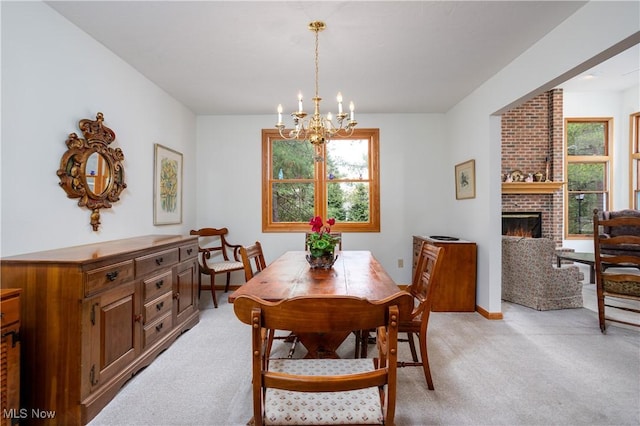 dining space featuring an inviting chandelier, a fireplace, and light carpet