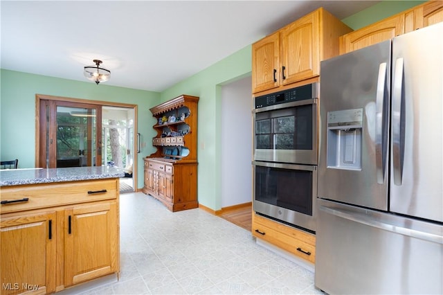 kitchen with appliances with stainless steel finishes and light stone countertops