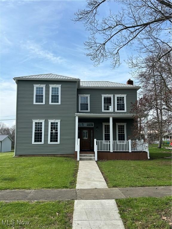 view of front of home with covered porch and a front lawn