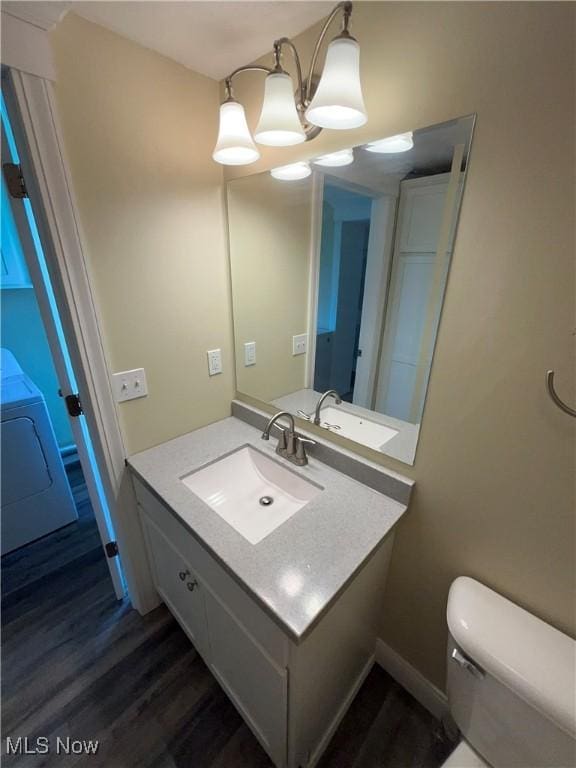 10545 Main St, Norwich, OH 43767 - bathroom with vanity, washer / clothes dryer, hardwood / wood-style floors, and toilet
