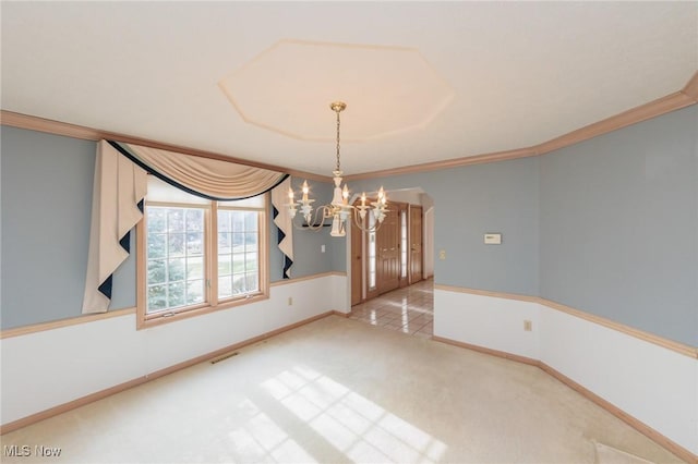 unfurnished dining area featuring a notable chandelier, carpet floors, and ornamental molding