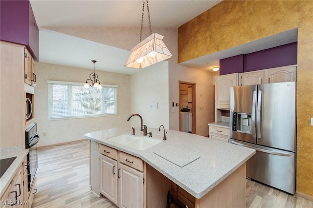 kitchen with pendant lighting, sink, light hardwood / wood-style flooring, a kitchen island with sink, and stainless steel appliances