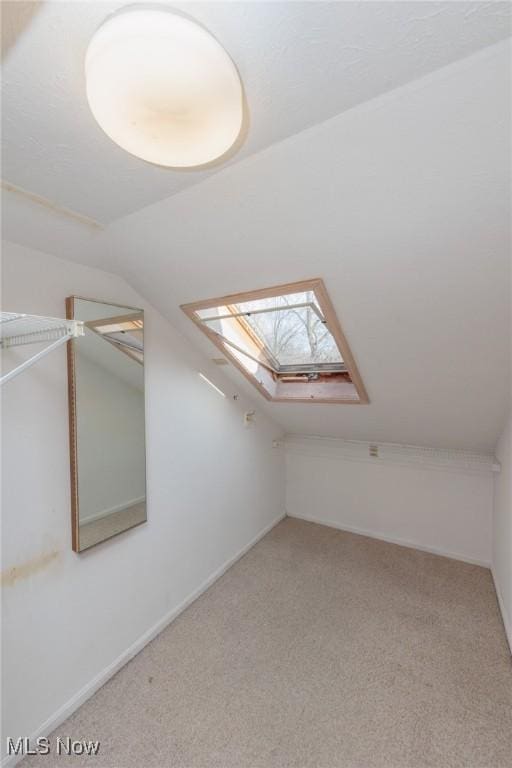 bonus room with lofted ceiling with skylight and carpet