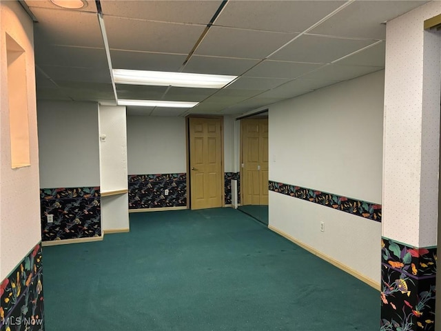 carpeted empty room with a paneled ceiling