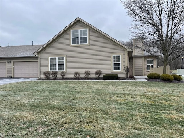 view of side of property featuring a garage and a lawn