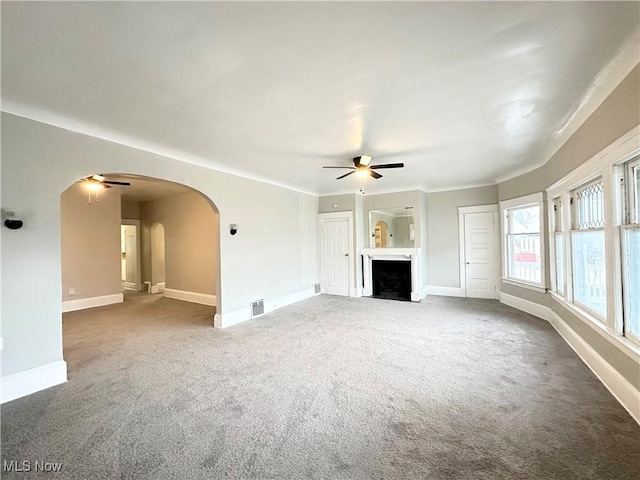 unfurnished living room featuring carpet floors and ceiling fan