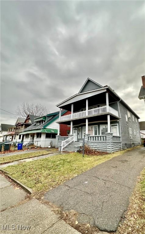 view of front of house with a balcony and a front yard