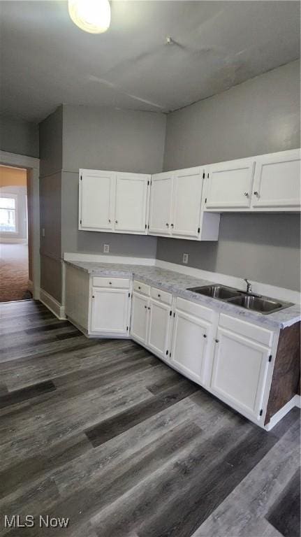 kitchen with sink, dark hardwood / wood-style floors, and white cabinets