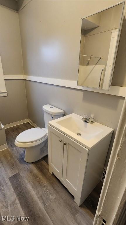 bathroom featuring vanity, hardwood / wood-style floors, and toilet