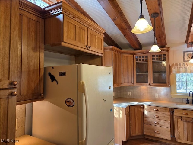 kitchen featuring decorative light fixtures, sink, backsplash, white refrigerator, and beam ceiling