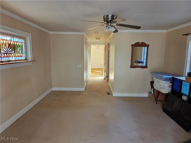 empty room featuring ceiling fan, light colored carpet, and ornamental molding