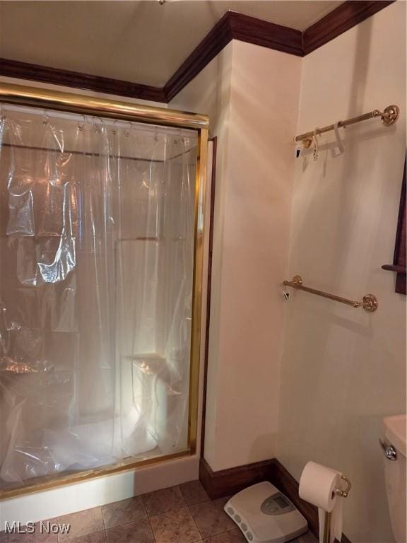 bathroom featuring ornamental molding, a shower with shower door, tile patterned floors, and toilet