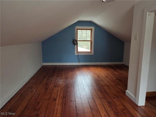 additional living space featuring lofted ceiling and dark hardwood / wood-style flooring