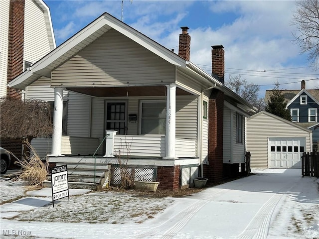 bungalow-style home with a garage, an outdoor structure, and covered porch