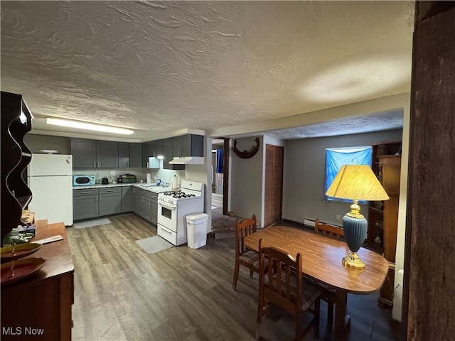 kitchen featuring sink, white appliances, gray cabinetry, light hardwood / wood-style floors, and a textured ceiling